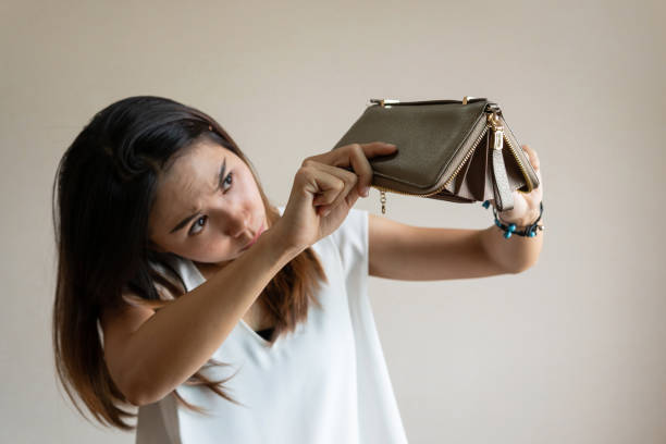Seorang wanita yang membuka dompet kosong / iStockphoto