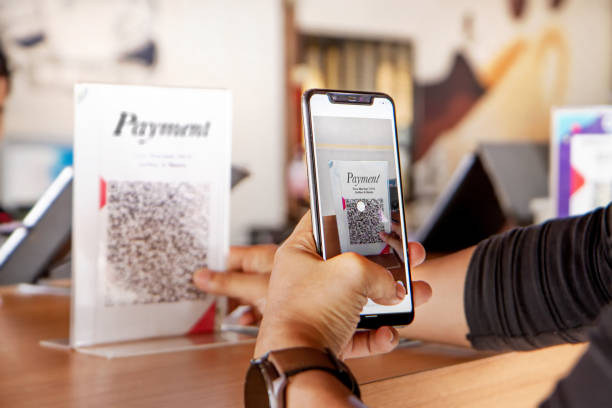 Pelanggan menggunakan telepon untuk pembayaran di restoran kafe / iStockphoto