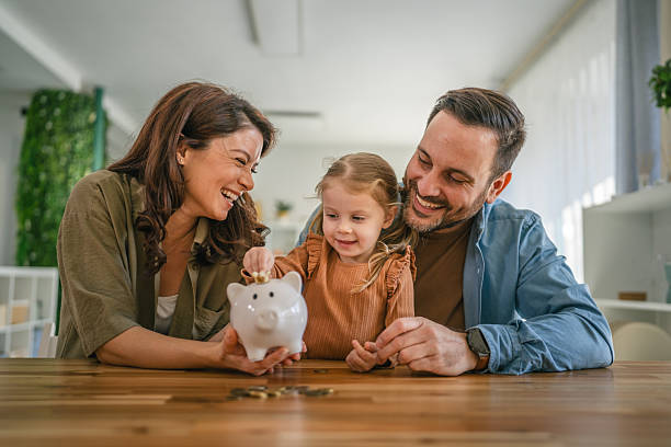 Keluarga mengajar anak tentang menabung dengan celengan / istockphoto