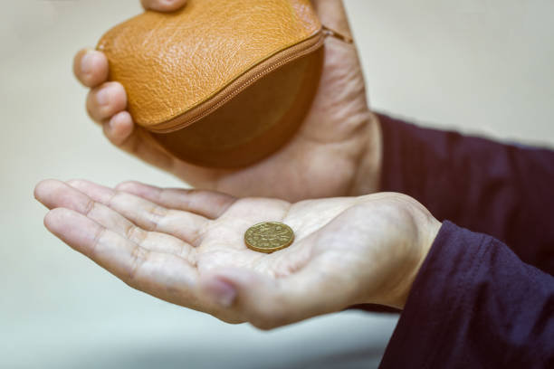 Tangan memegang koin satu dolar dan kantong uang kecil / iStockphoto
