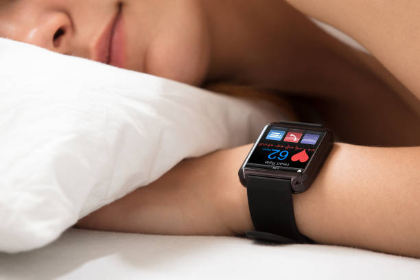 Jam Tangan Pintar Menunjukkan Detak Jantung Di Tangan Wanita yang Tidur / iStockephoto