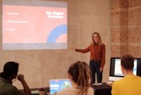 Wanita muda mempresentasikan konsep evolusi digital seperti AI dan big data dalam sebuah seminar / pexels-mikael-blomkvist