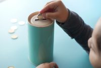 Seorang anak meletakkan koin ke dalam celengan / pexels-towfiqu-barbhuiya